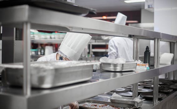 Chefs working diligently in a modern stainless steel kitchen, preparing delicious dishes.